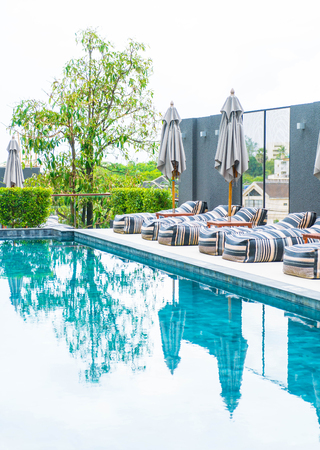 Beautiful luxury umbrella and chair around outdoor swimming pool in hotel and resortの写真素材