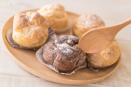 cream puff on wood plateの写真素材