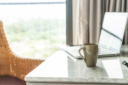 coffee cup with laptop and beautiful luxury table decoration in livingroom interior for background - vintage filterの写真素材