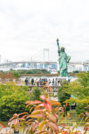 TOKYO - November 16 2016: A crowd of tourists and locals enjoy the view of the Tokyo Bay from Odaiba on a cloudy Autumn afternoon, with the statue of liberty in the foreground, on November 16, 2016の写真素材