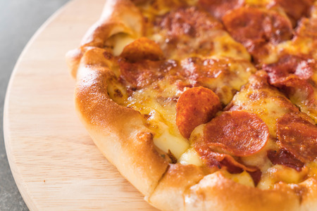 Homemade Pepperoni Pizza on wood plate - Unhealthy and Junk foodの写真素材