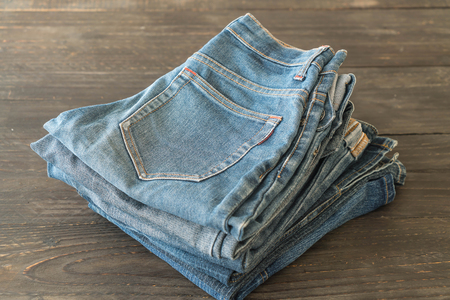 stacks of jeans clothing on wood backgroundの写真素材