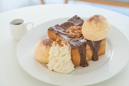 honey toast with vanilla ice-cream and chocolate on plateの写真素材