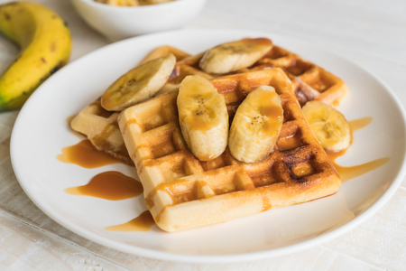 banana waffle with caramel on white plateの写真素材