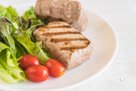 tuna steak with salad on wood tableの写真素材
