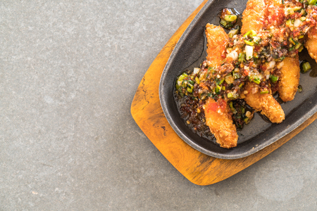 fried fish stick with spicy sauce on hot plateの写真素材