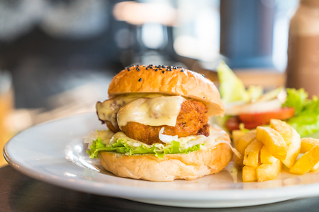 fried chicken burger with cheese and french friesの写真素材