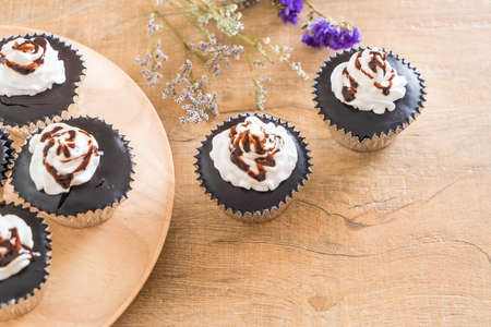 chocolate cup cake with whipped cream on tableの写真素材