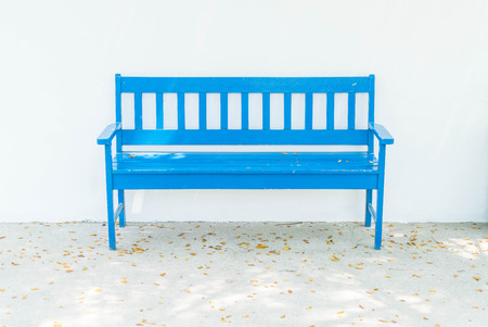 empty blue bench with white wallの写真素材
