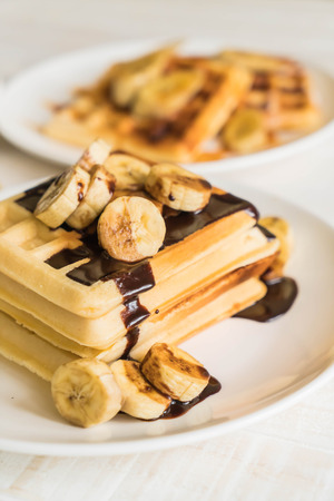 banana waffle with chocolate on white plateの写真素材