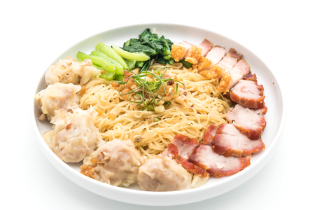 Egg noodle with red roast pork, crispy pork and dumplings on white backgroundの写真素材