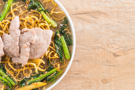 crispy egg noodles with chinese broccoli and pork with condimentsの写真素材