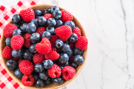 fresh blueberry and rasberry on wood bowlの写真素材