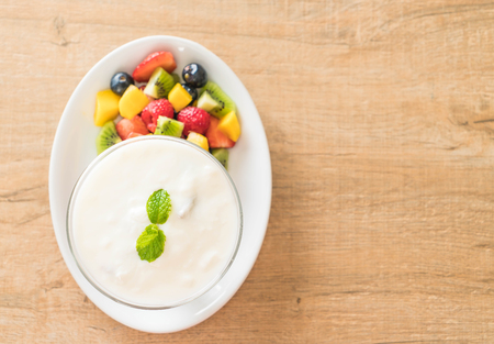 yogurt with mixed fruit (strawberry, blueberries, raspberry, kiwi, mango) on white plateの写真素材