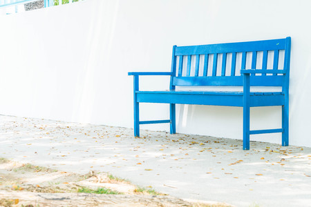 empty blue bench with white wallの写真素材
