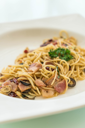 stir-fried spaghetti with bacon and garlic on white plateの写真素材