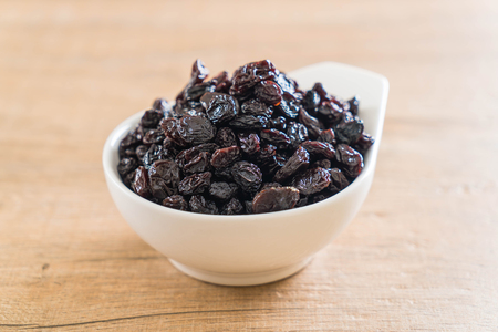 black raisins in bowl on tableの写真素材