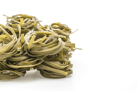 dried spinach fettuccine pasta on white backgroundの写真素材
