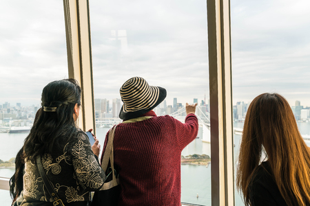 TOKYO - November 16 2016: A crowd of tourists and locals enjoy the view of the Tokyo Bay from Odaiba on a cloudy Autumn afternoon, on November 16, 2016のeditorial素材