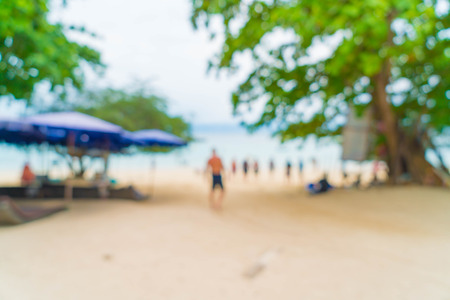 abstract blur beautiful palm with umbrella and chair on sea and beach for backgroundの写真素材