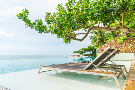 Beautiful luxury umbrella and chair around outdoor swimming pool in hotel and resort - boost up color processingの写真素材