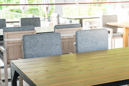 Empty sidewalk cafe with chairs and pillow
