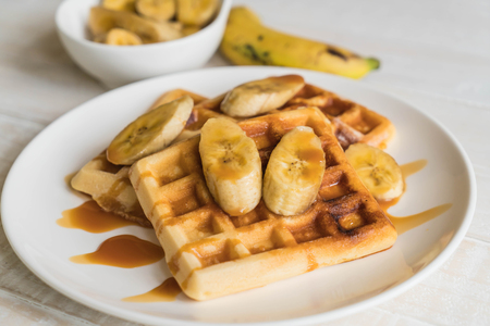 banana waffle with caramel on white plateの写真素材