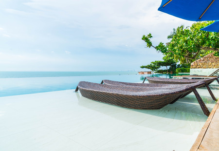 Beautiful luxury umbrella and chair around outdoor swimming pool in hotel and resort - boost up color processingの写真素材
