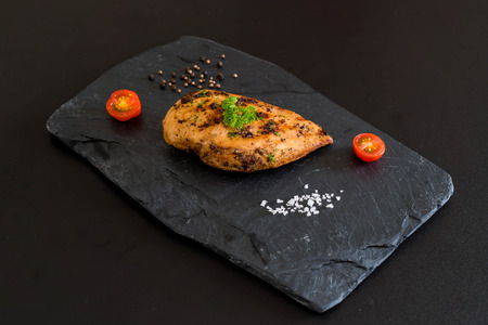 Grilled chicken fillets on slate plateの写真素材