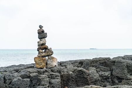 stone towers on basaltic rocks at Hyeopjae Beach,Jeju Island, South Koreaの写真素材