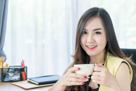 asian business woman happy with coffee cup in office