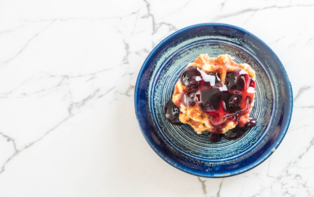 waffle with blueberry sauce on the tableの写真素材