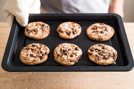 cookies with dark chocolate chips on baked trayの写真素材