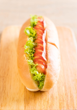 sausage hotdog with ketchup on wood boardの写真素材