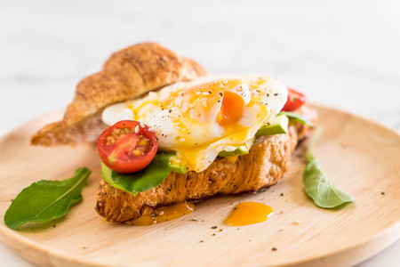 egg benedict with avocado, tomatoes and salad - healthy or vegan food styleの写真素材