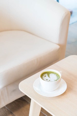 hot green tea latte cup in coffee shopの写真素材