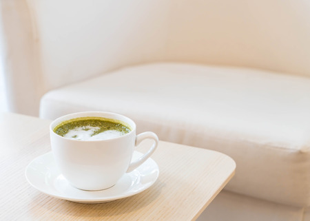 hot green tea latte cup in coffee shopの写真素材