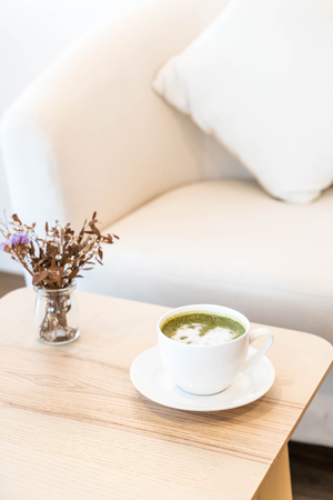 hot green tea latte cup in coffee shopの写真素材