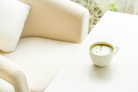 hot green tea latte cup in coffee shopの写真素材