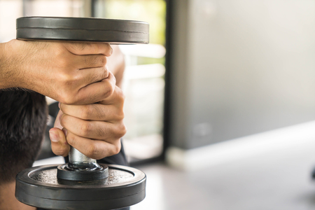 Close-up Hand holding dumbbell in gymの写真素材