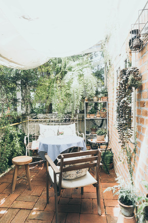 empty outdoor patio table and chair decoration in garden - vintage effect filterの写真素材