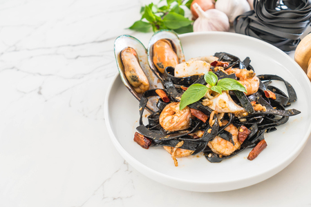 black spaghetti or pasta with seafood on plateの写真素材