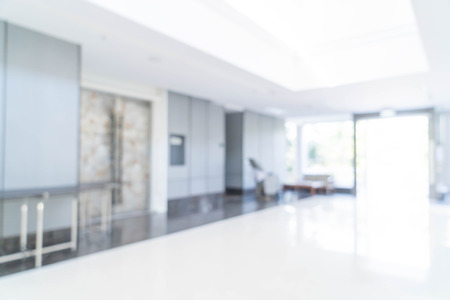 Blurred abstract background interior view looking out toward to empty office lobby and entrance doors and glass curtain wall with frame - blue white balance processing styleの写真素材