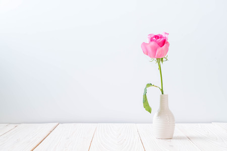 pink rose in vase on wood background with copy spaceの写真素材