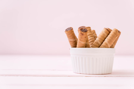 rolled wafer filled with cocoa cream on wood backgroundの写真素材