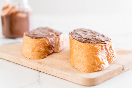 bread with chocolate hazelnut spread on wooden board