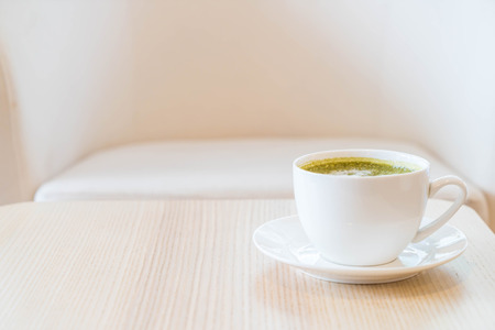Hot green tea latte cup in coffee shopの写真素材