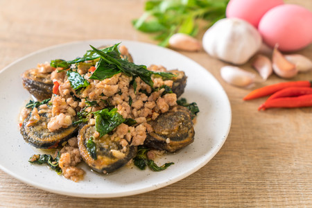 Stir-fried Century Egg and Minced Pork with Holy Basil Leaves on plateの写真素材