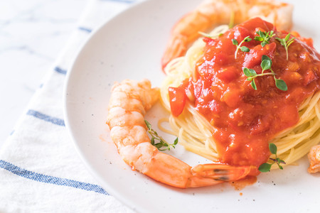 spaghetti with tomatoes sauce and shrimps on plateの写真素材
