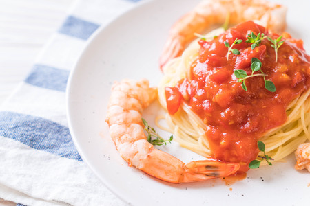 spaghetti with tomatoes sauce and shrimps on plateの写真素材